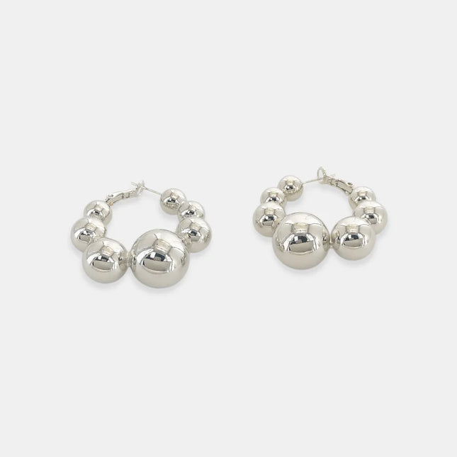 Bead pattern hoops earrings with seven beads. Lift latch and side the earring post into your ears featuring rhodium plated, triple plated earrings
